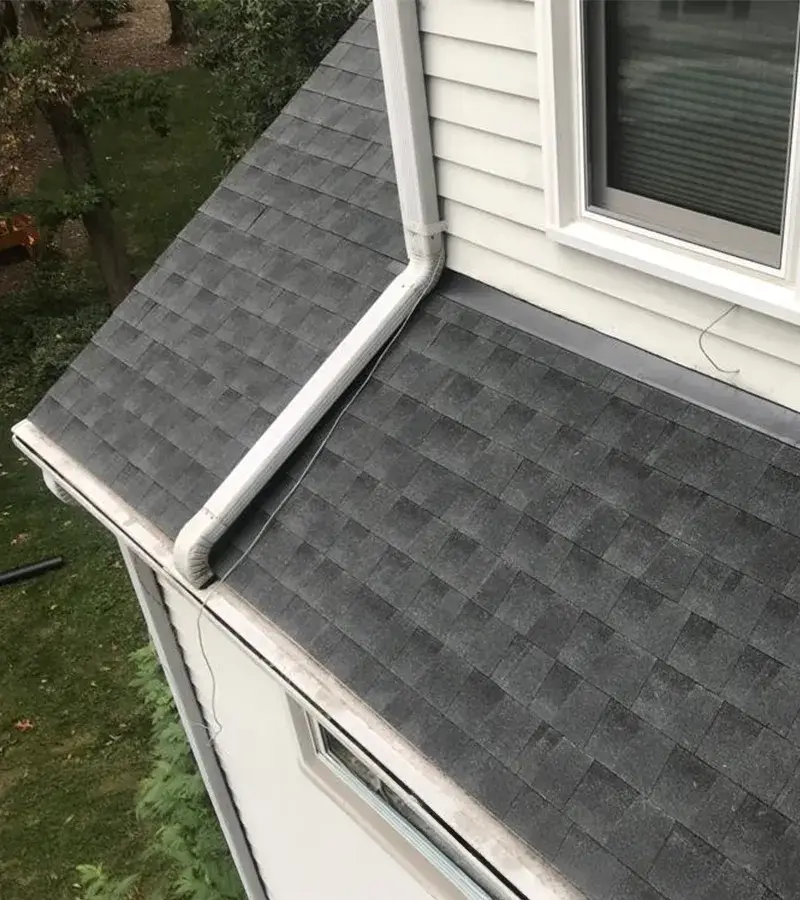 A detached shed with a green standing seam metal roof.