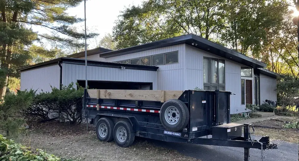 A detached shed with a green standing seam metal roof.