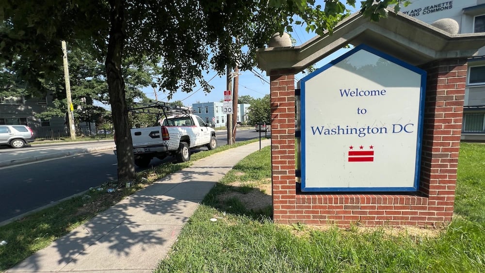 Capitol Improvements work truck next to Welcome to Washington DC sign before a residential roofing installation in Northeast Washington DC